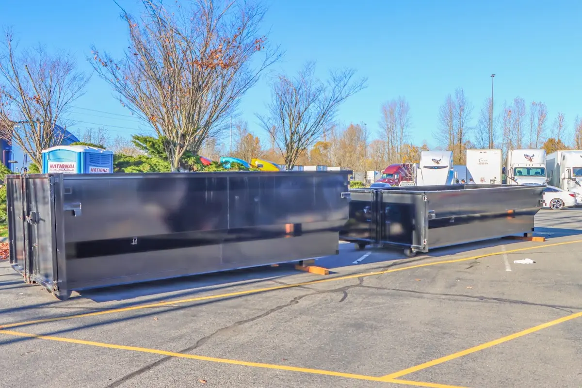 Professional dumpster rental service with roll-off container on residential driveway in Comstock